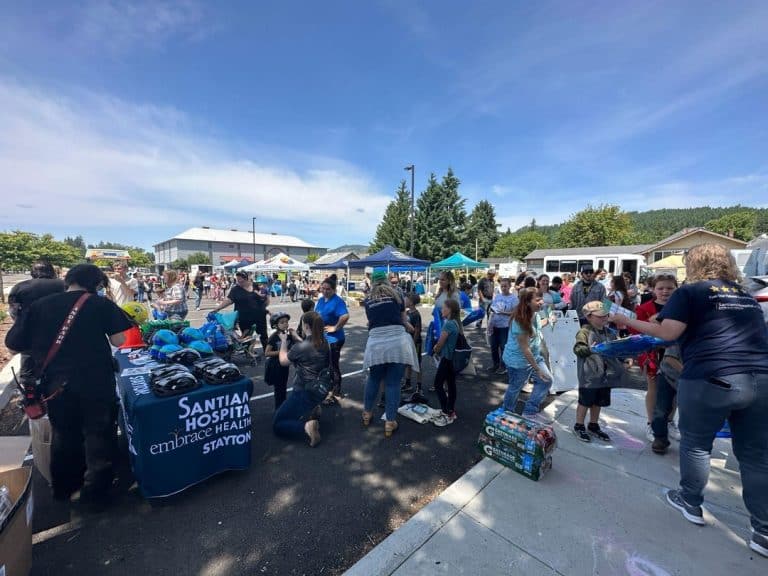 Community members visiting resource tables at an outdoor Santiam Hospital event